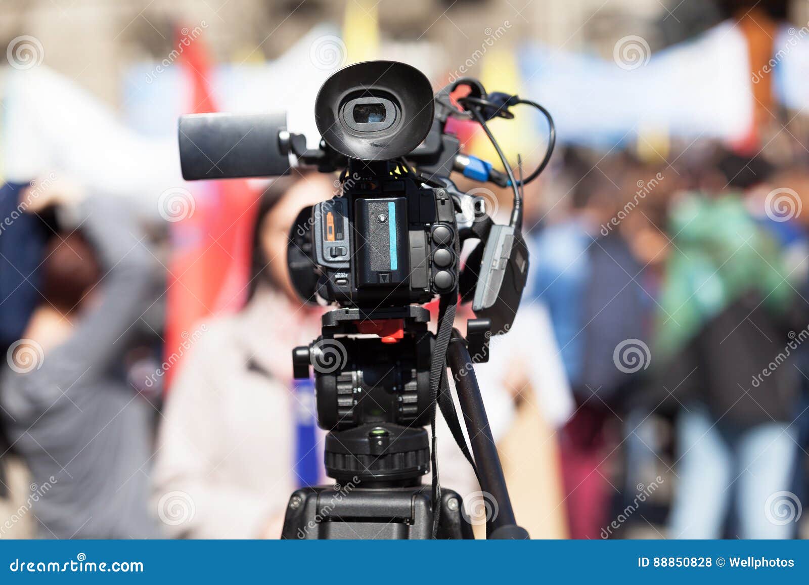 Filming Female Reporter with a Video Camera, Blurred Crowd in the ...