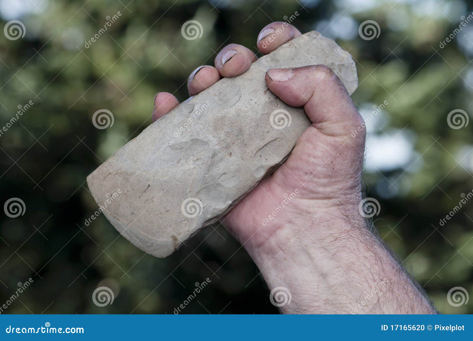 filthy hand holding handaxe
