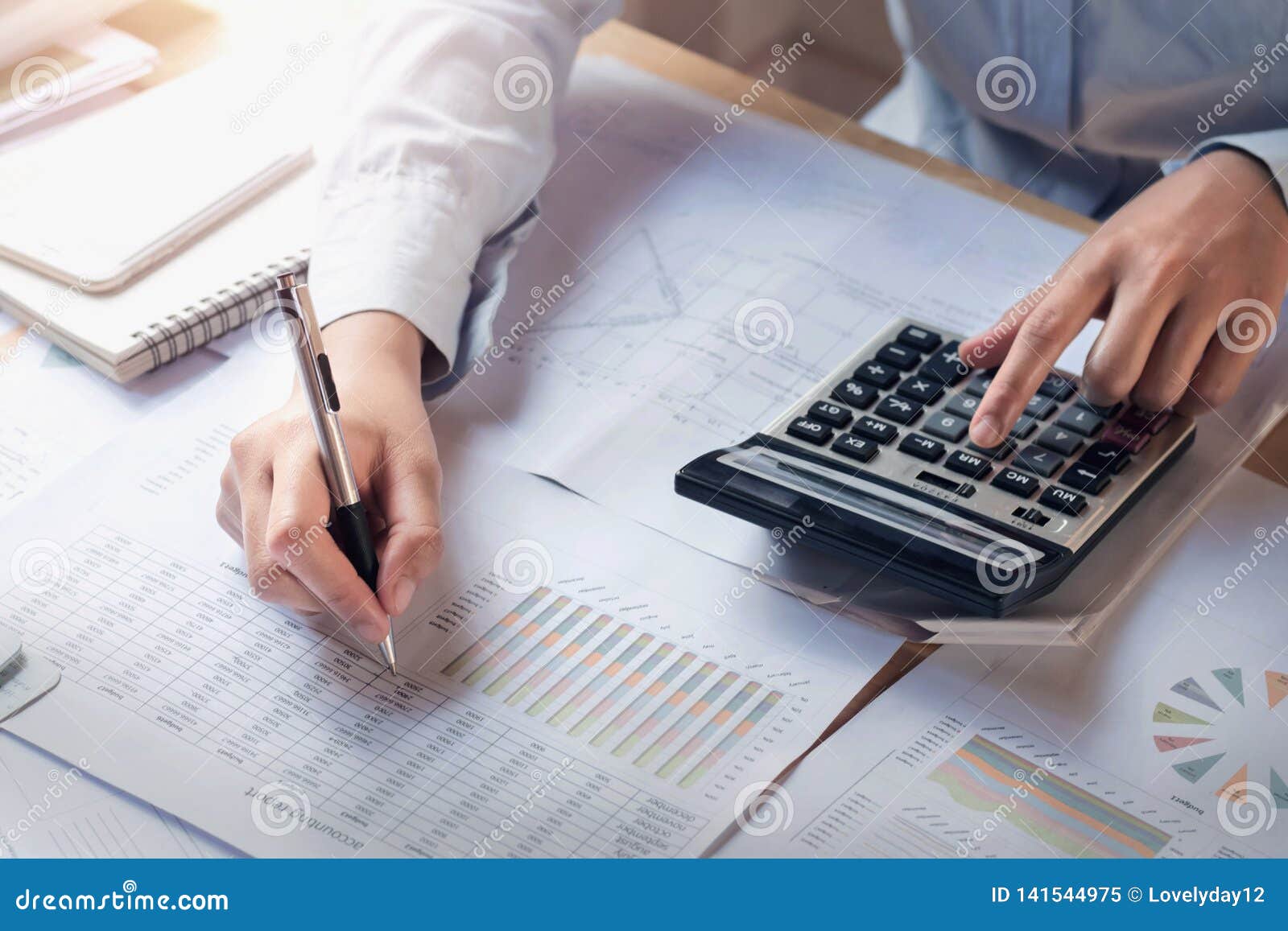 finance and accounting concept. business woman working on desk using calculator to calculate