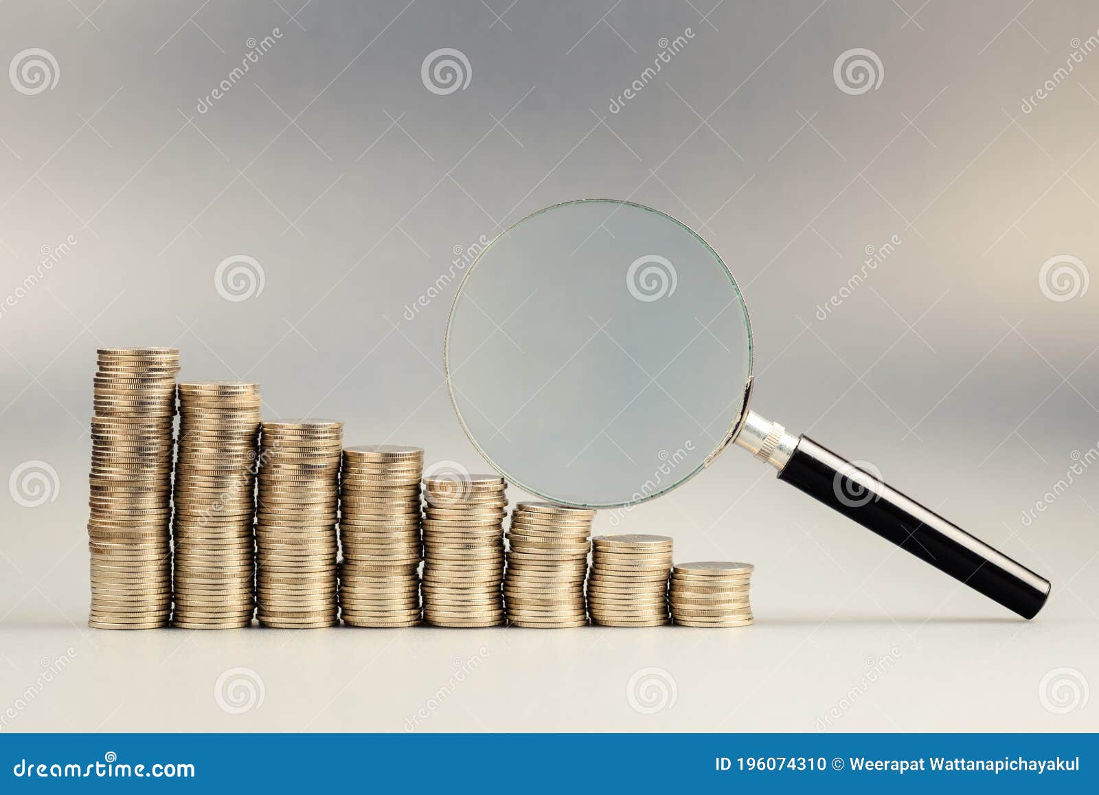 Pile of coins and magnifying glass. Finance, economy, stock market