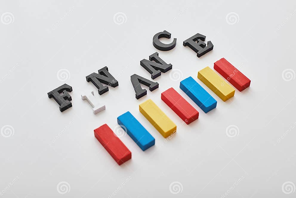 finance-word-created-with-cubes-alphabet-letters-near-multi-colored-wooden-blocks-lying