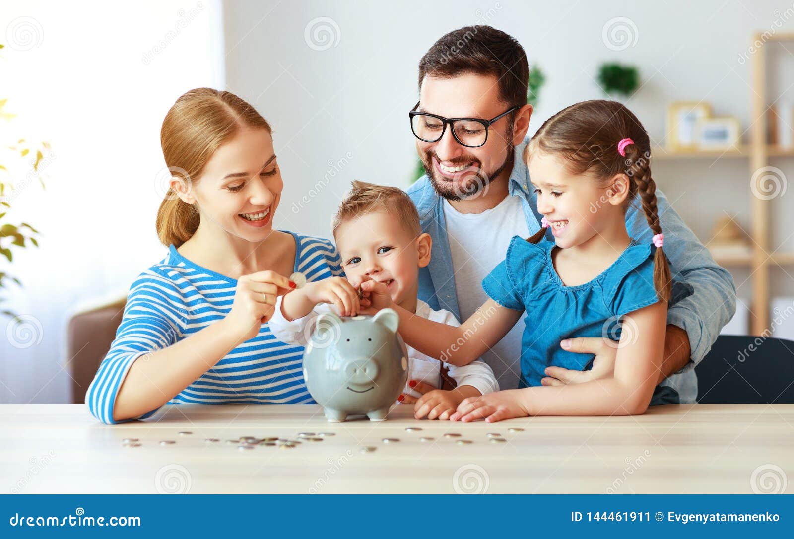 financial planning   family mother father and children with piggy bank at home