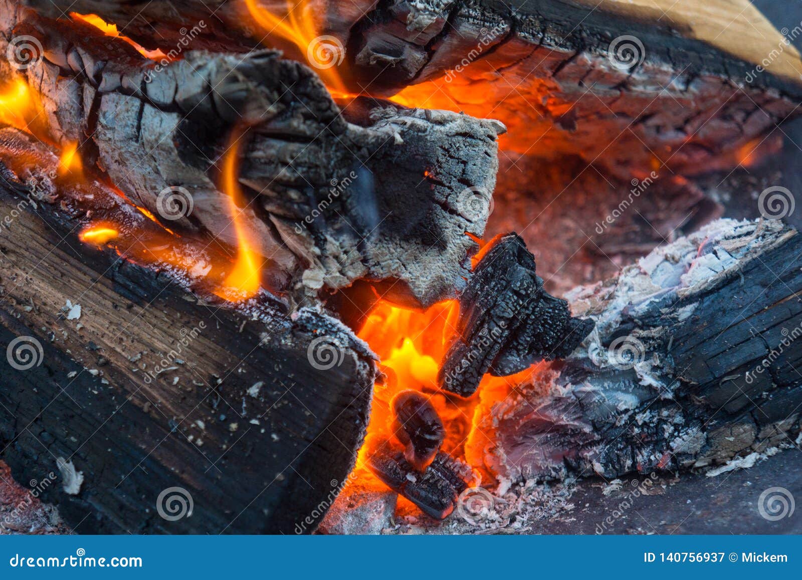 Fine sui tizzoni del fuoco di legno con la fiamma ed il fumo. Chiuda sulla combustione collega il fuoco ed il fumo Il falò dei ceppi di legno spaccati ha avuto dadi giù per calmare le fame di consumo Perfezioni per riscaldarsi il giorno di inverno freddo