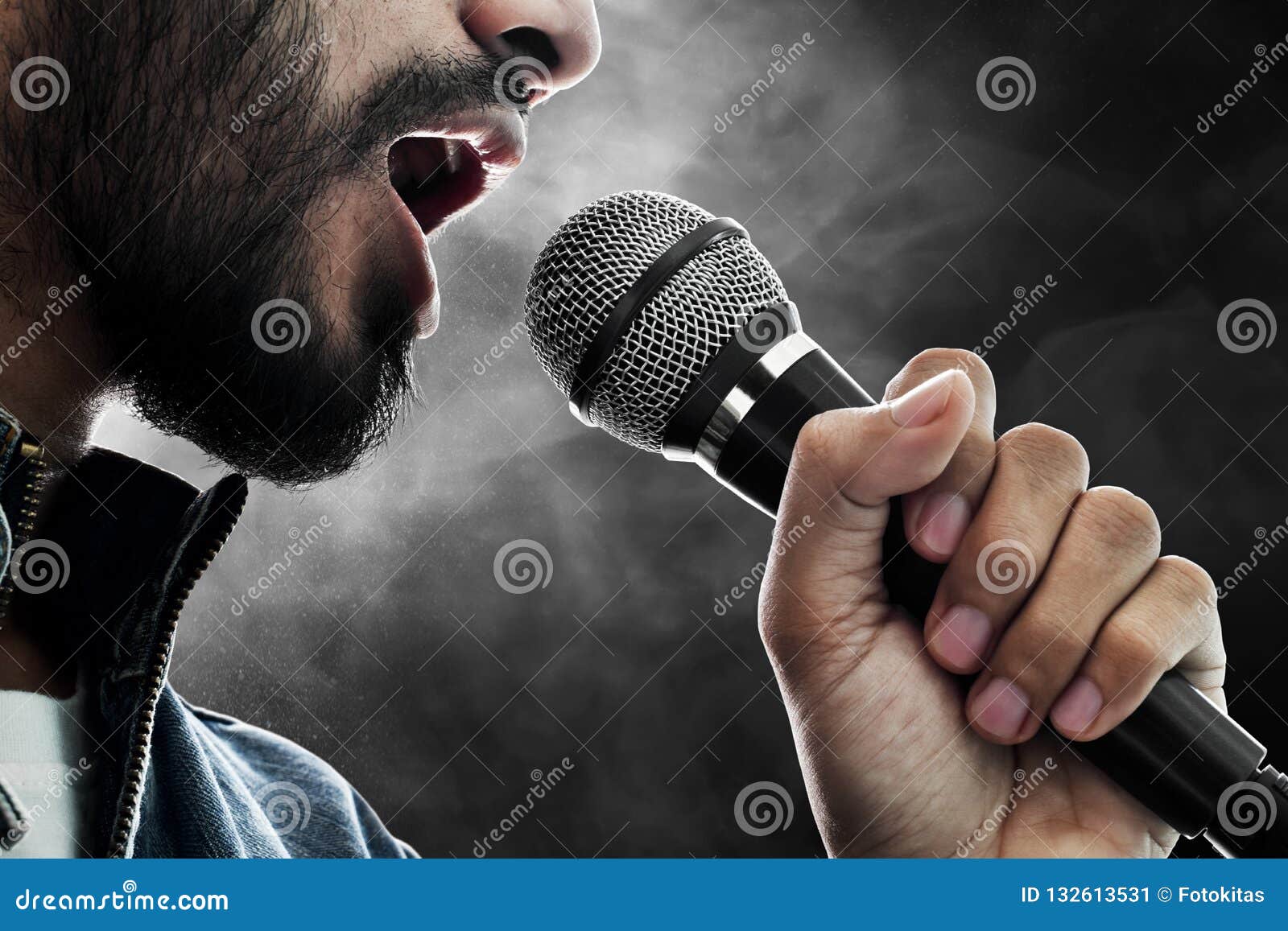 Il cantante tiene in mano un microfono professionale per cantare o  registrare il suono Foto stock - Alamy