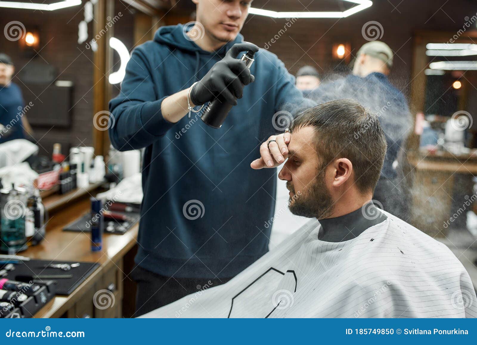 Finishing Touch. Barber Fixing with Hairspray New Haircut of Young Bearded  Man Sitting in Barber Shop Chair Stock Photo - Image of fixing, chair:  185749850