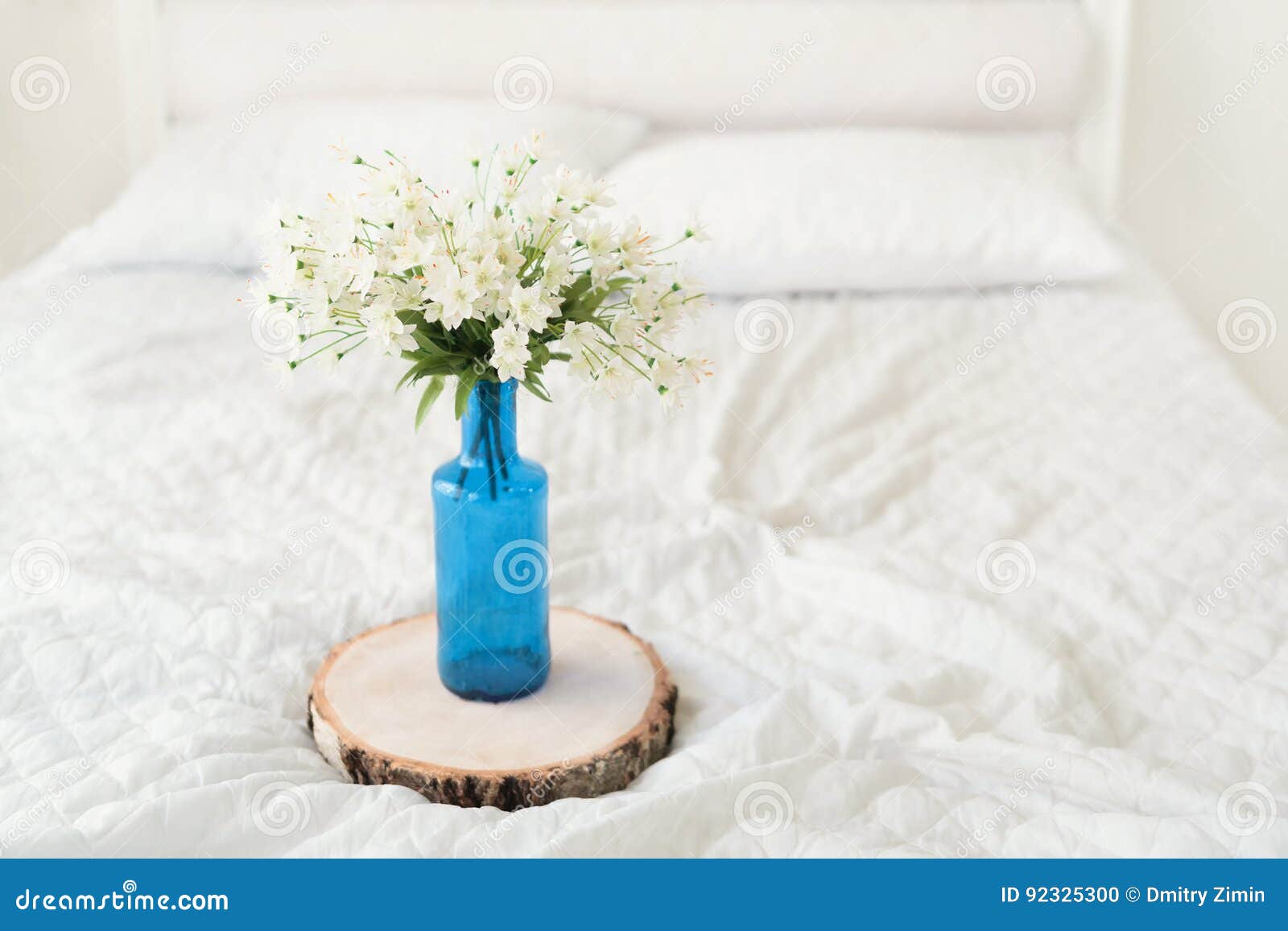 Fiori Bianchi In Vaso Di Fiore Blu Sul Letto Fotografia Stock - Immagine di luce, cuscini: 92325300