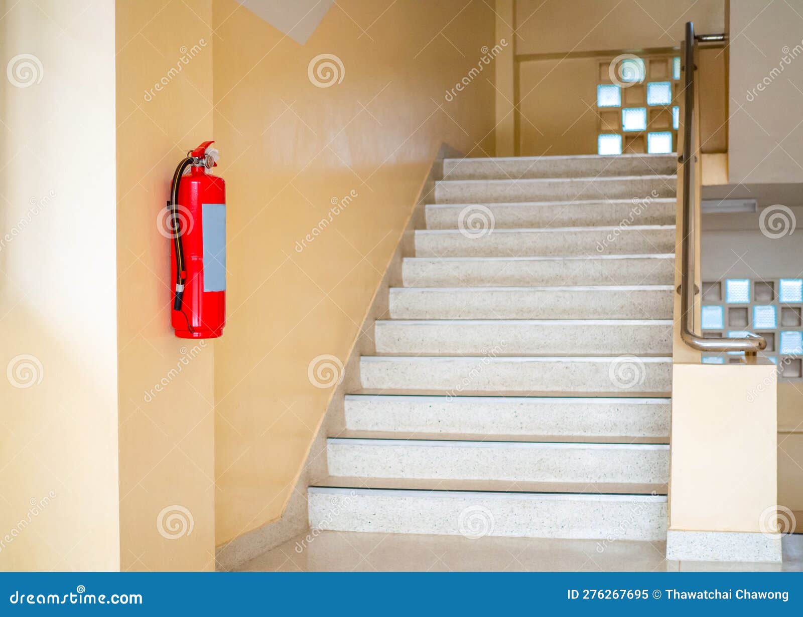 A Fire Extinguisher Hangs Up the Stairs. Fire Safety Concept Stock