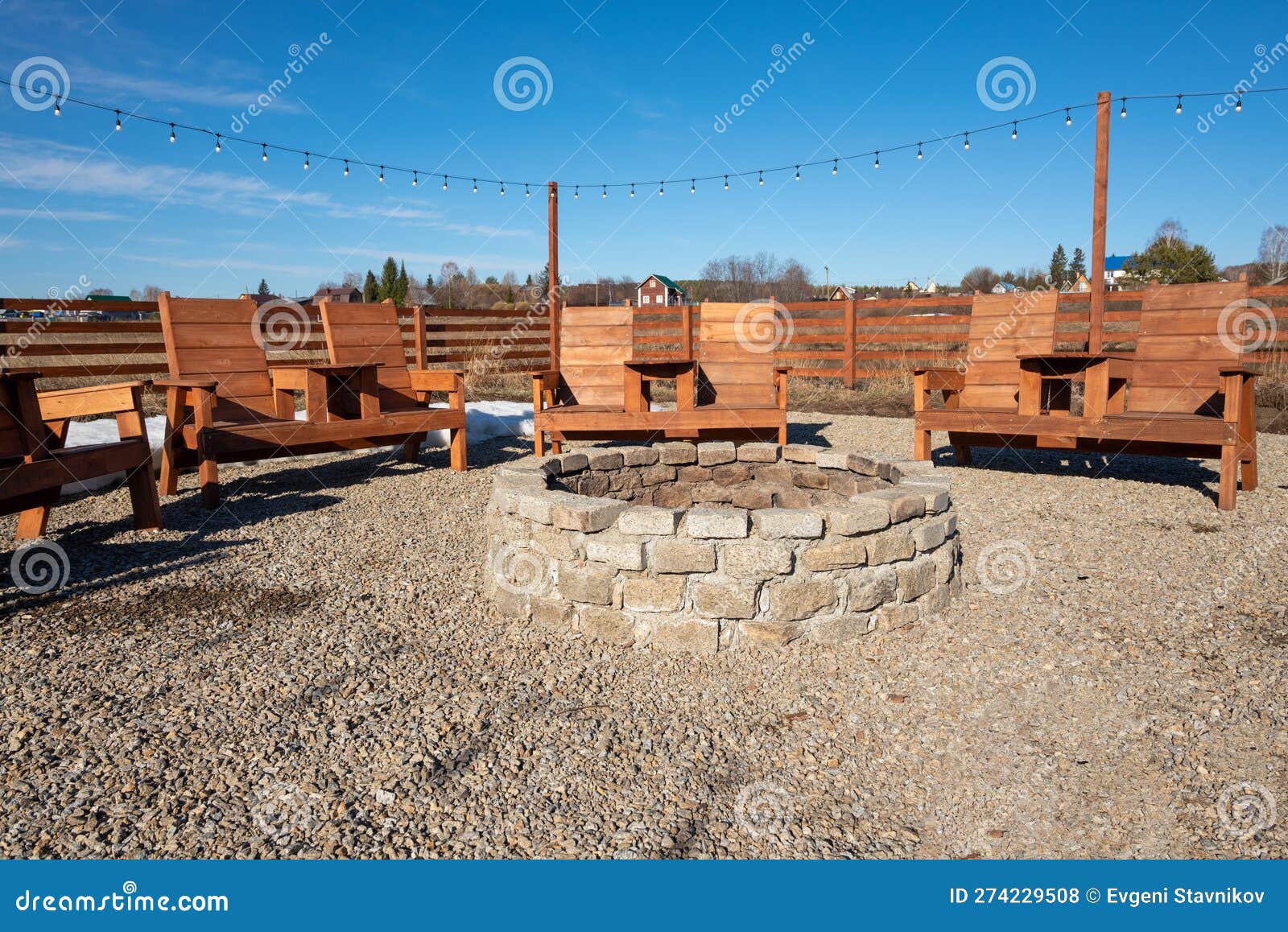 A Fire Pit with a String of Lights Hanging from the Top. Stock Photo
