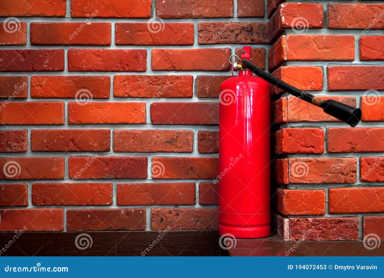 Fire Safety Background with Fire Extinguisher on the Red Bricks Wall