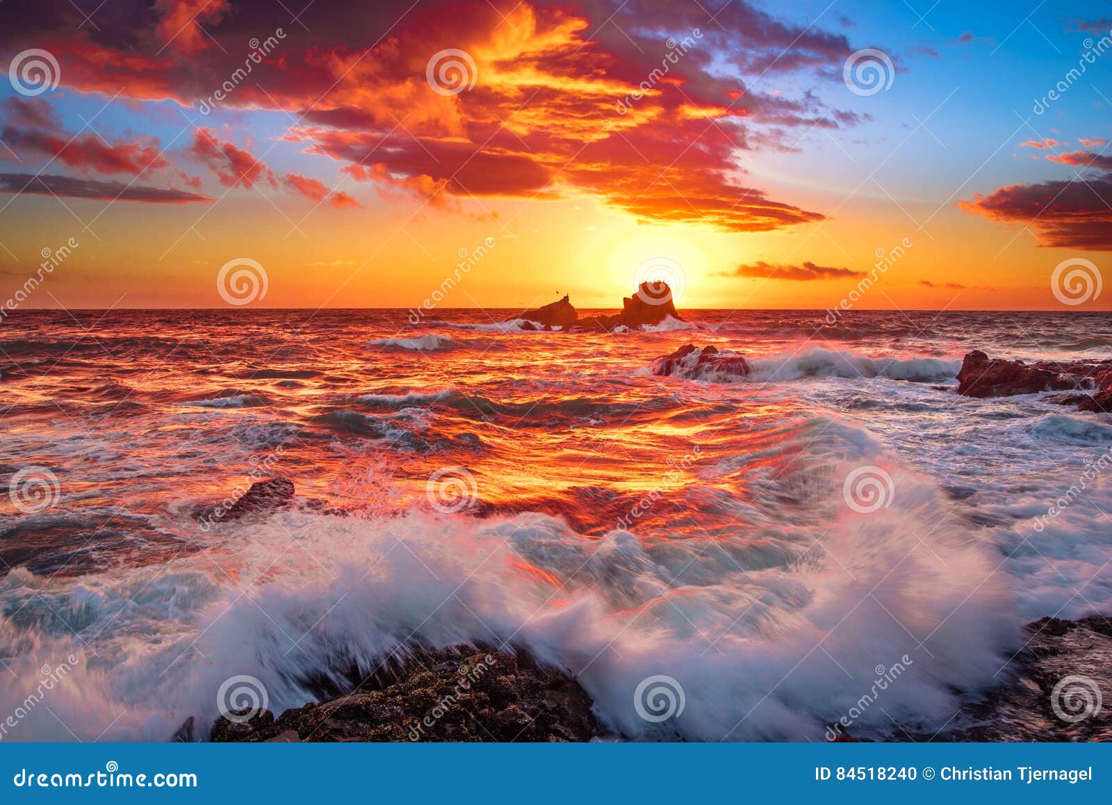 fire sky and waves crashing over rocks in laguna beach, ca