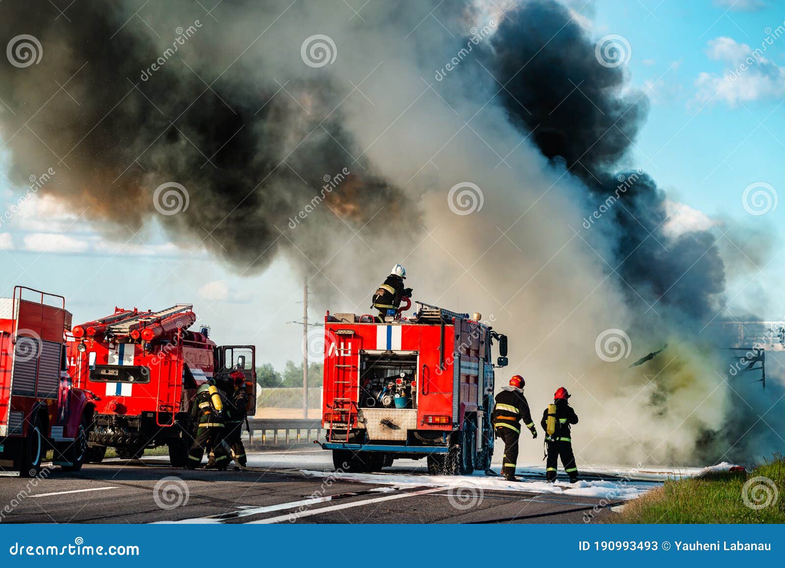 Firefighter Extinguishes a Burning Car after an Accident Stock Image