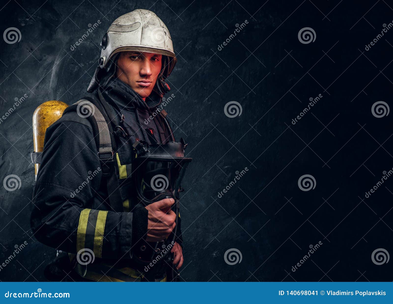 Firefighter in Full Protective Equipment Holding an Oxygen Mask and