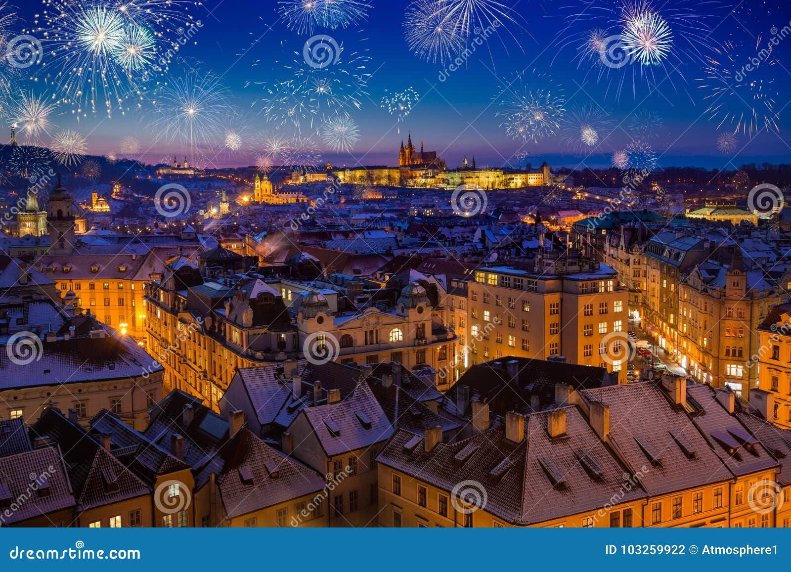 fireworks above prague castle with snowy rooftops during late christmas sunset