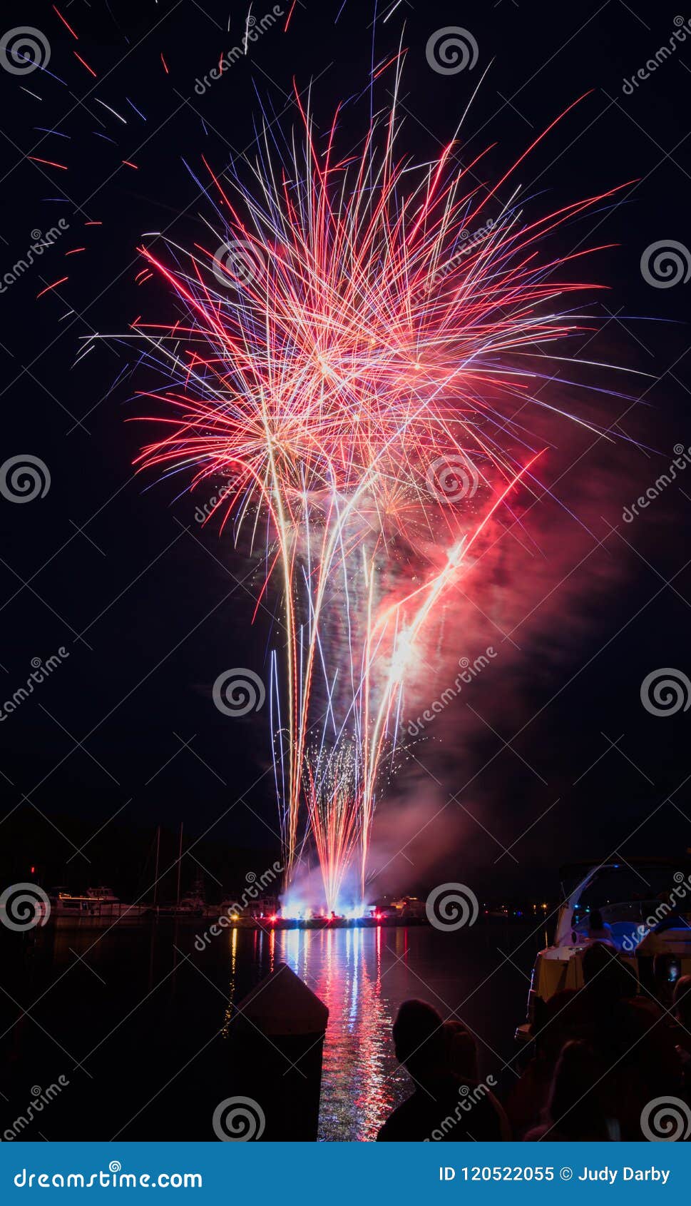 red fireworks explode over the tchefuncte river in madisonville, louisiana