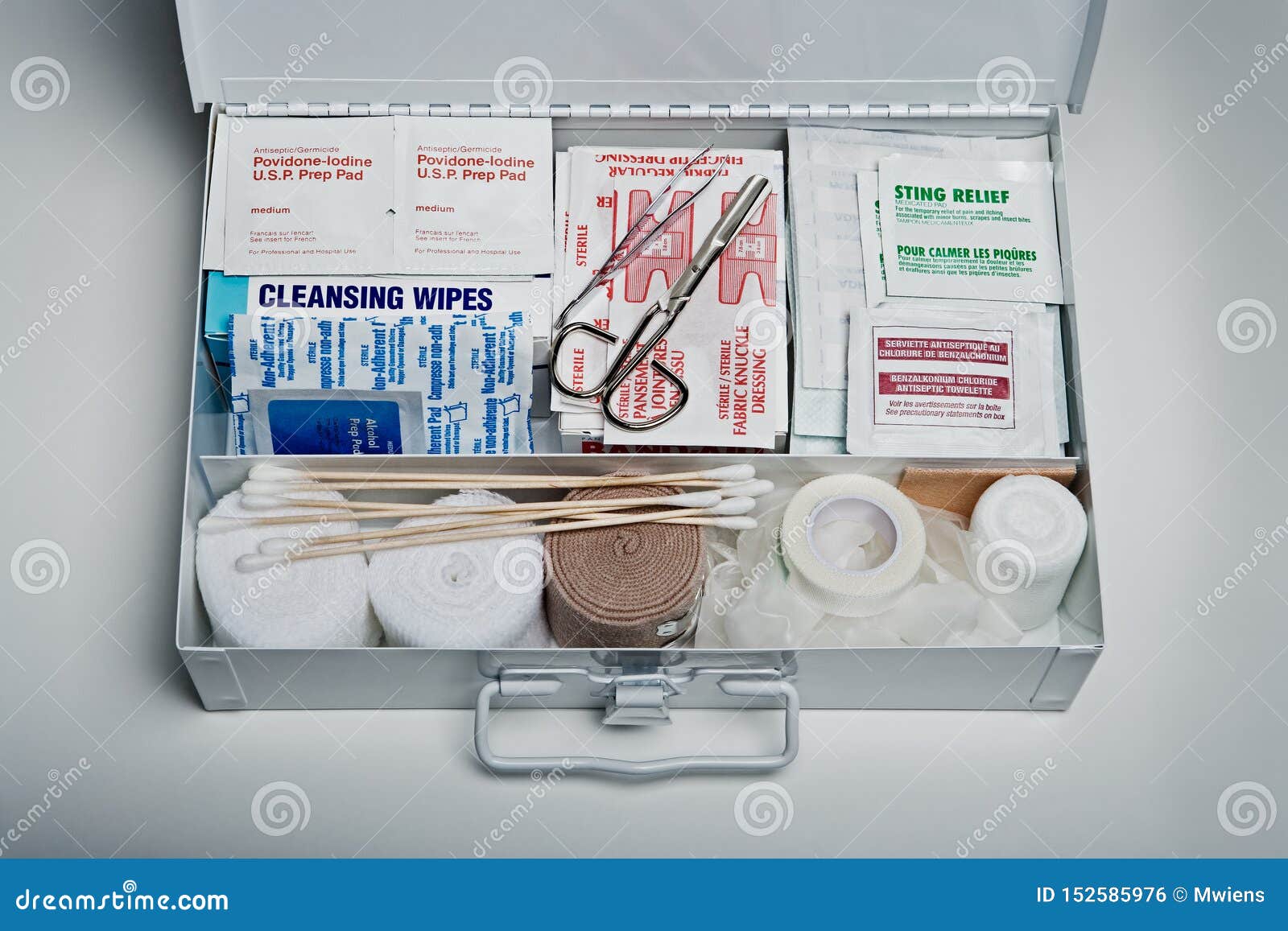 first aid kit packed with medical supplies on grey background