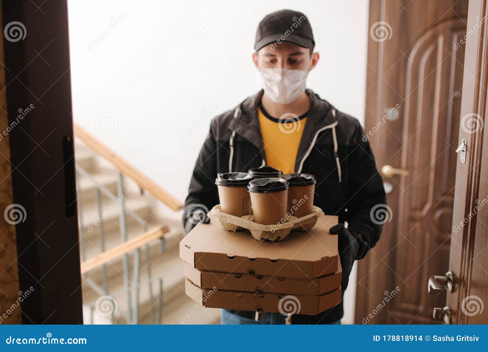 first persom view of delivery man in mask and gloves give pizza and coffe. stay home