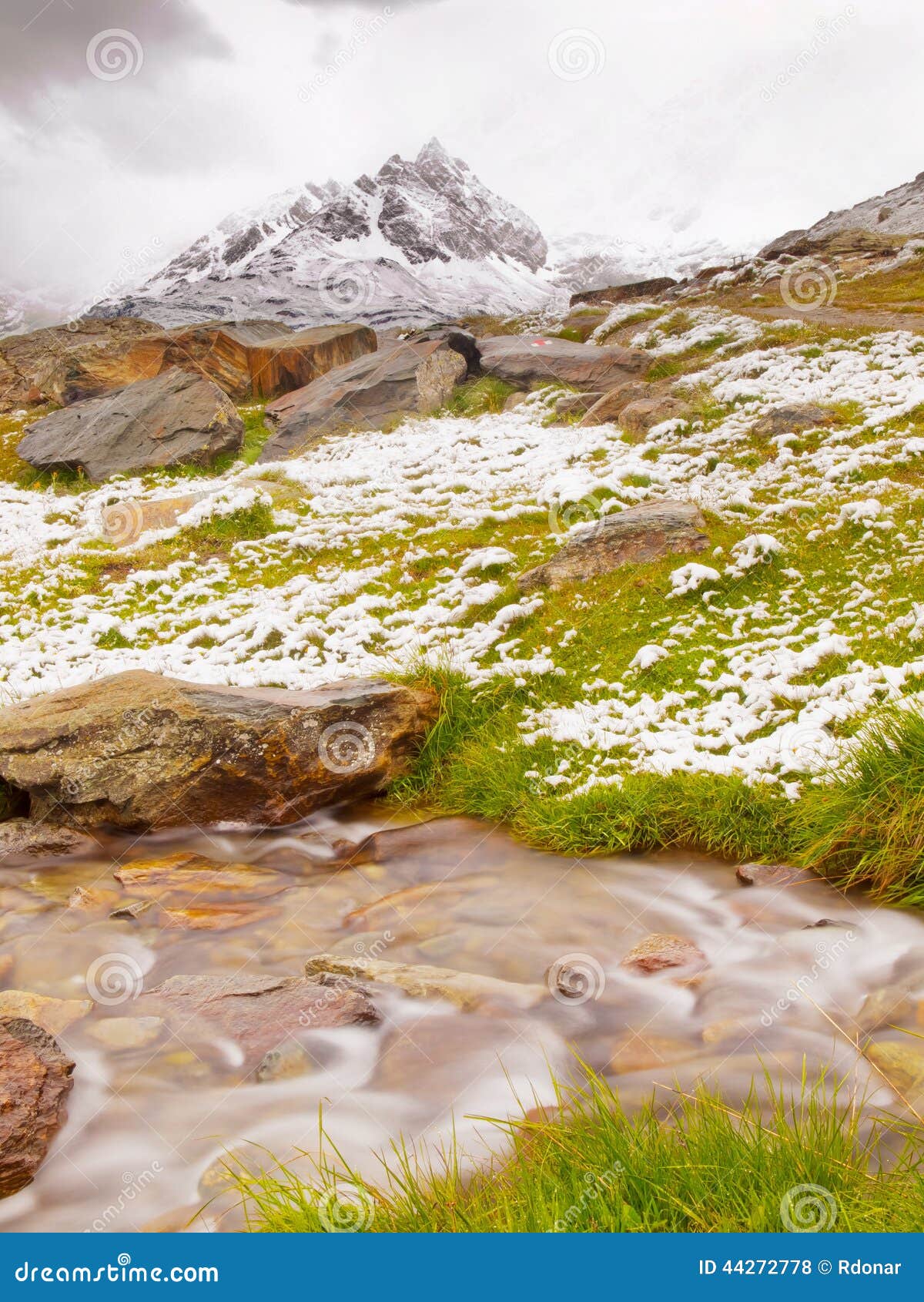 First Snow In Alps Touristic Region Fresh Green Meadow With Rapids