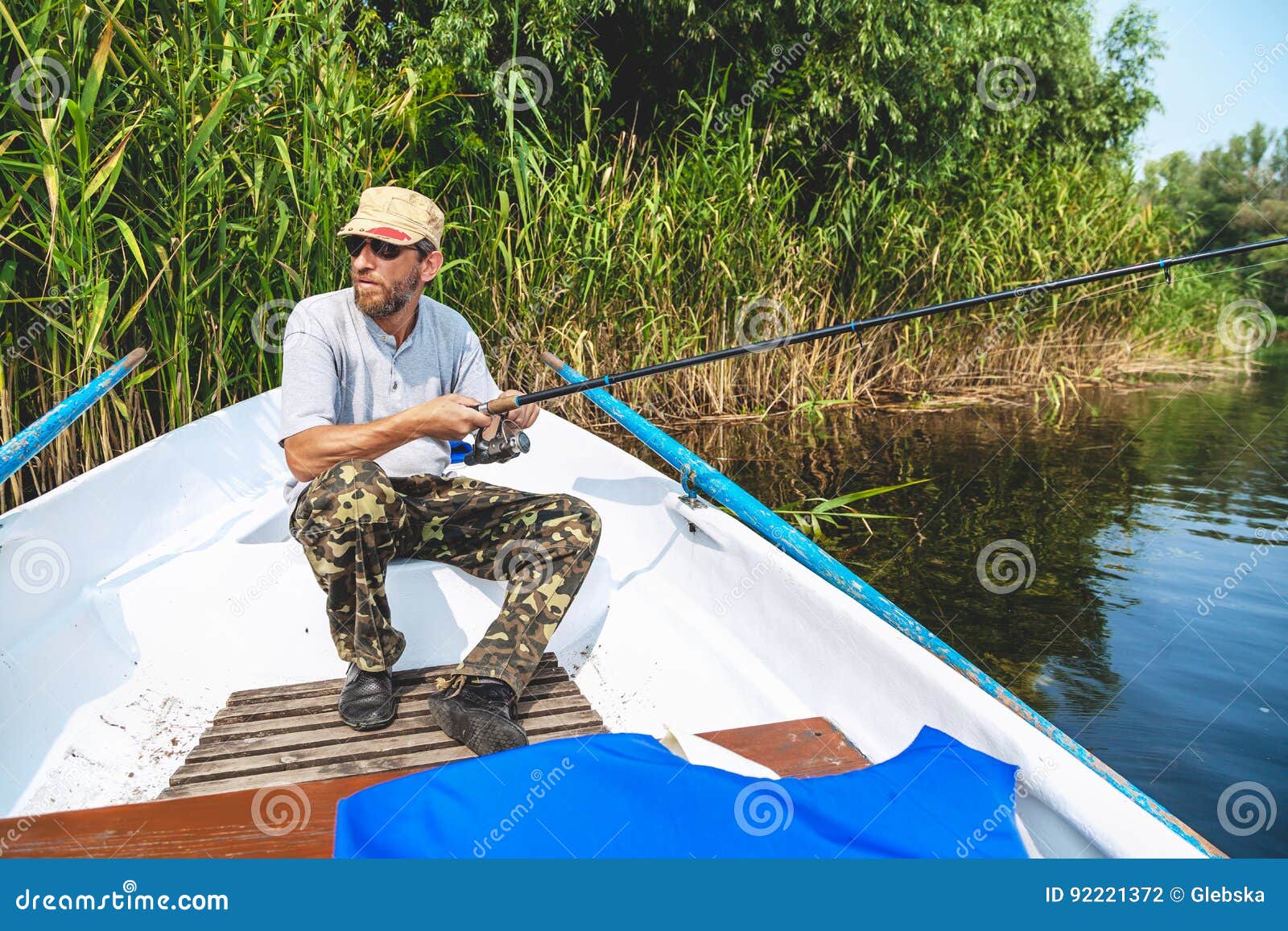 Fischer Mit Dem Bart, Der Im Boot Sitzt Und Angelrute Hält Stockfoto