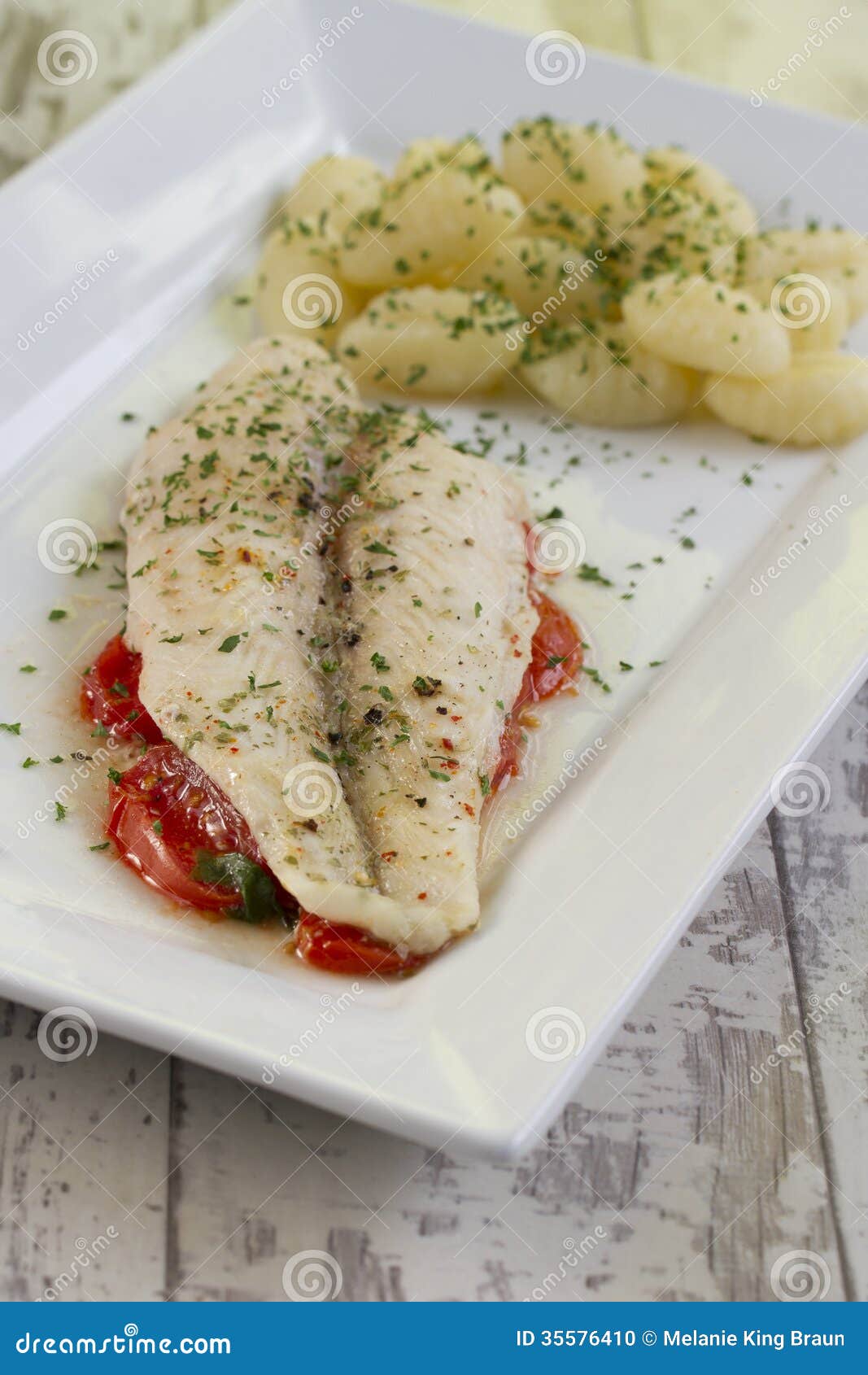 Fischfilet Auf Tomatenbett Mit Gnocchi Stockfoto - Bild von seelachs ...