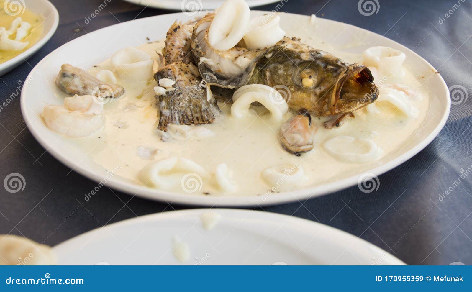 fish with calamaris in the wine and garlic sauce in the mediterranian restaurant