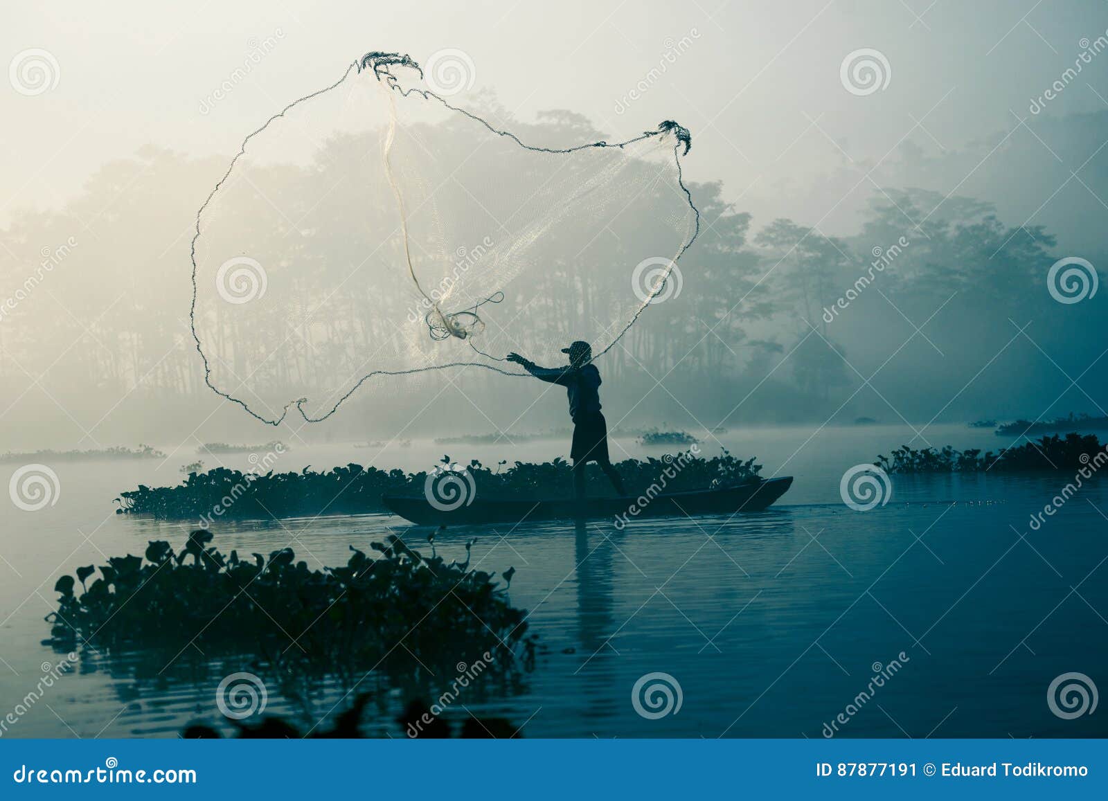 fisherman casting out his fishing net in the river.