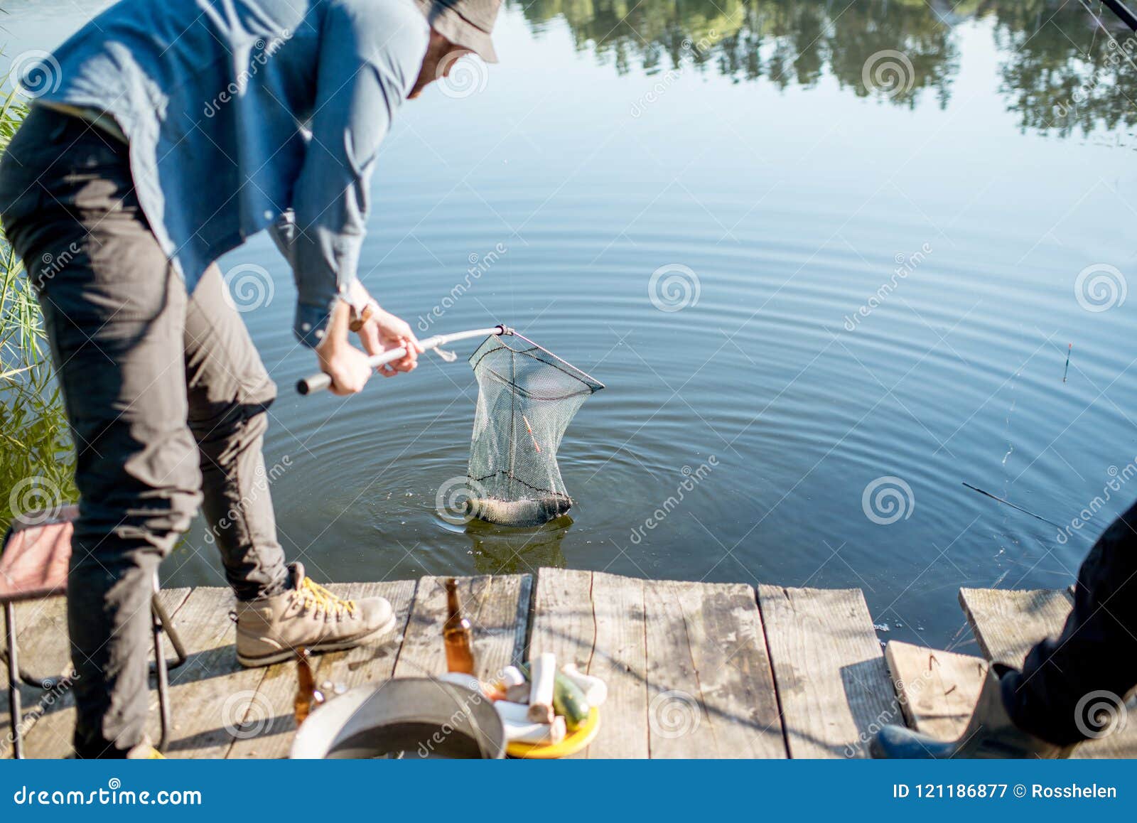 https://thumbs.dreamstime.com/z/fisherman-catching-fish-fisherman-catching-big-fish-fishing-net-lake-morning-121186877.jpg