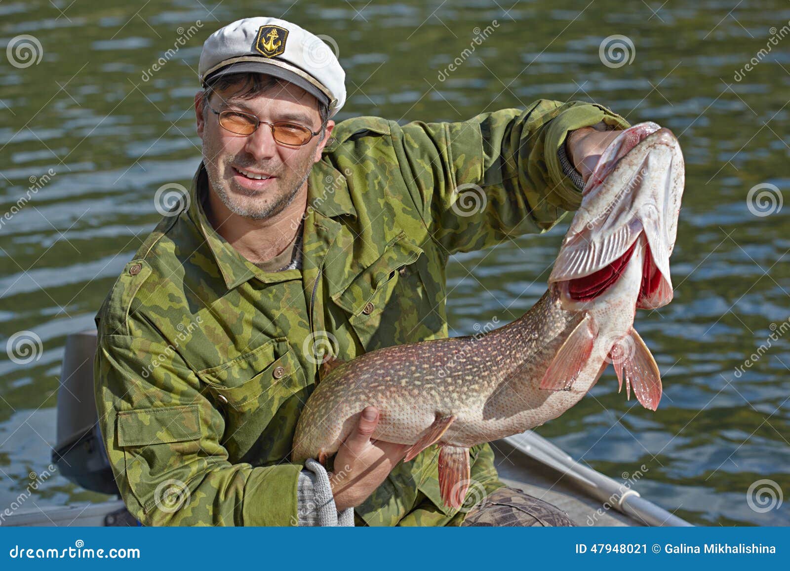 Fisherman holding a big pike
