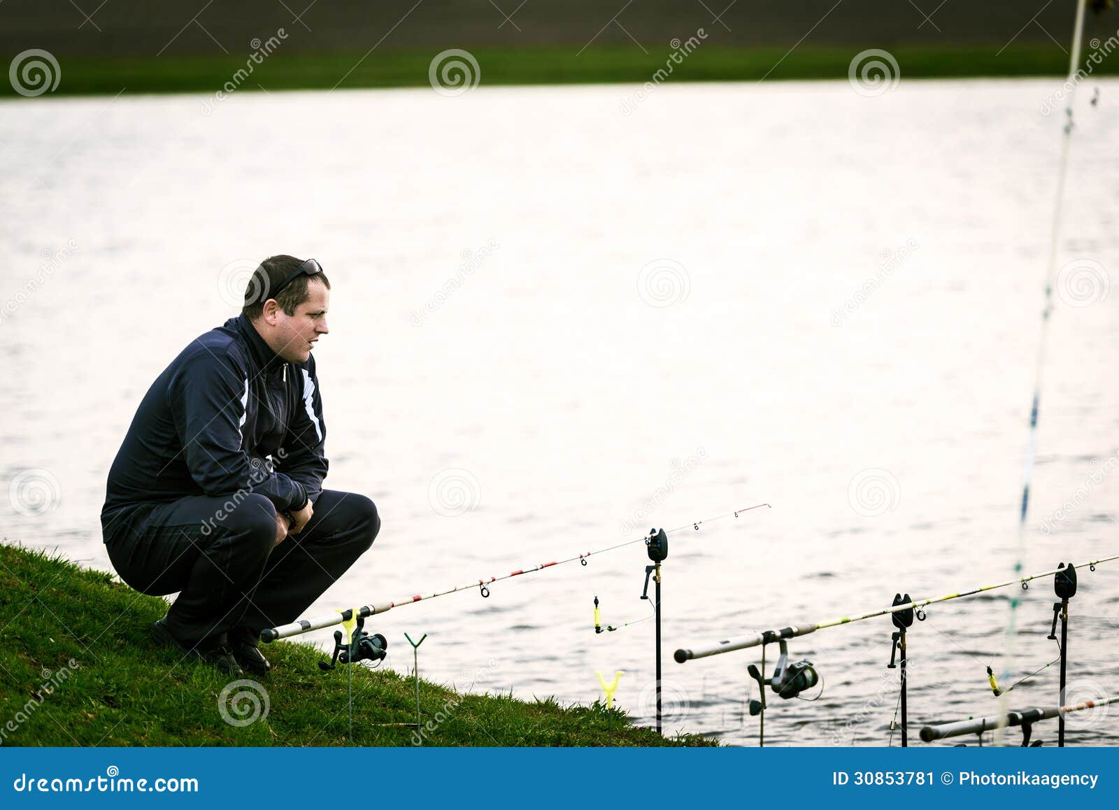 Fisherman Looking at His Rods Waiting for a Fish Stock Image