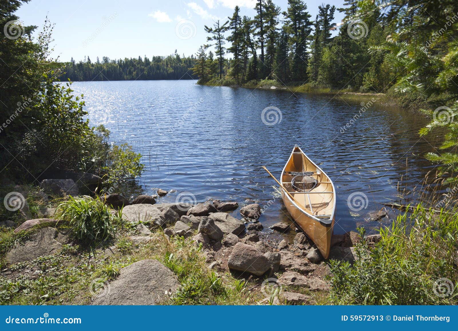 a fisherman's canoe on rocky shore in northern minnesota lake