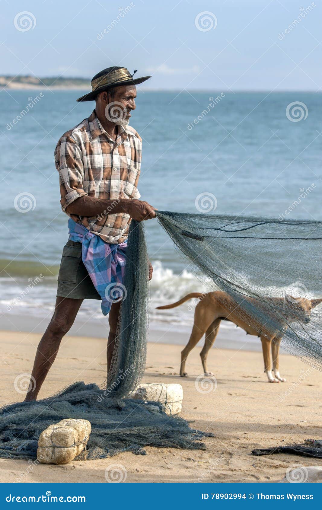 A Fisherman Sorting a Fishing Net on Arugam Bay Beach in the Early