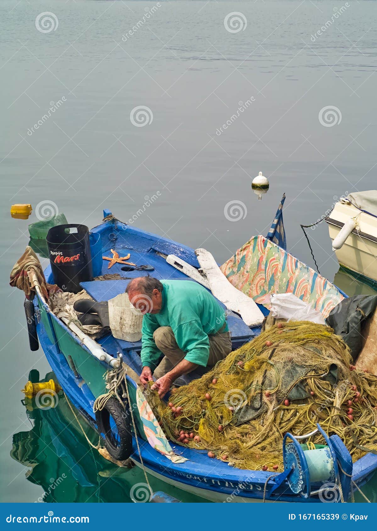 Fisherman Working on His Fishing Nets in Traditional Weathered Blue Wooden  Boat in the Port of Kavala Editorial Stock Image - Image of boat,  reflection: 167165339