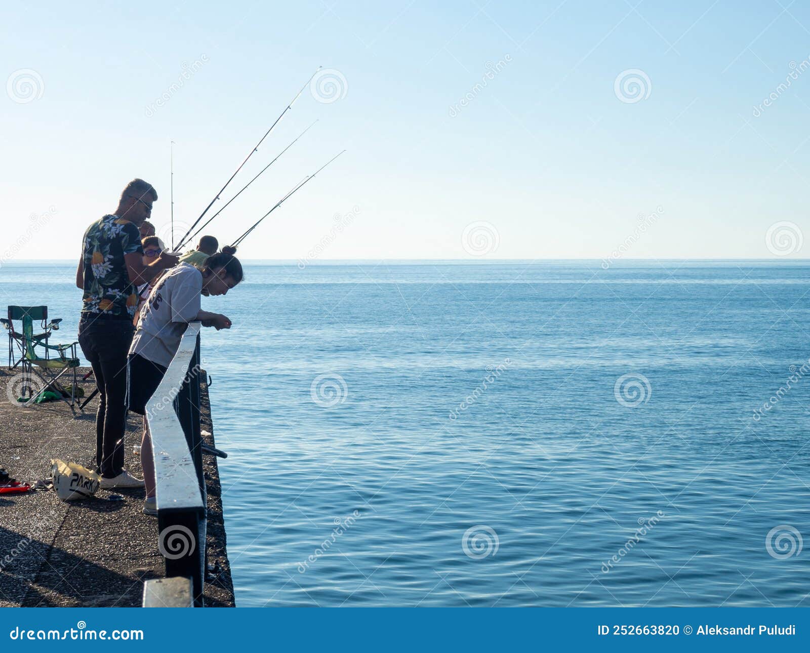 Fishermen are Fishing from the Pier. Pier of Ships. Lots of Fishermen.  Nibble. Fishing Season Editorial Image - Image of activity, shoreline:  252663820
