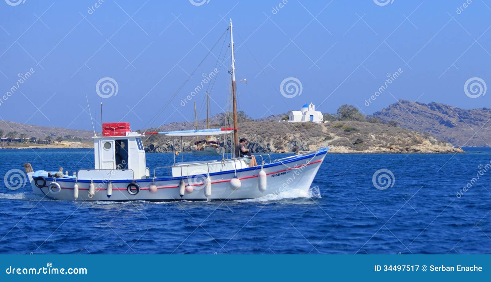 Greek fishing boat painted in typical blue and white colors sailing 