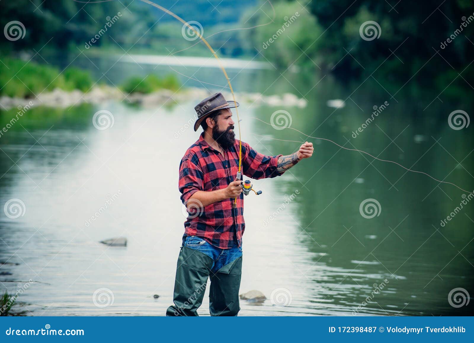 Fishing. Brutal Man Stand in River Water. Man Bearded Fisher. Man