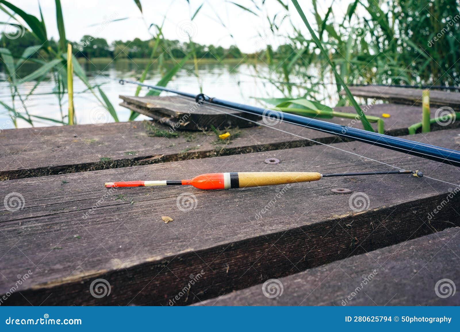 Fishing Float, Fishing Bobber on the Wooden Pier. Fishing Rod and