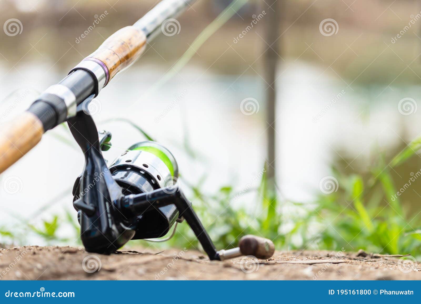 Fishing Reel and Rod in Fisherman Hand in a Pond Stock Photo