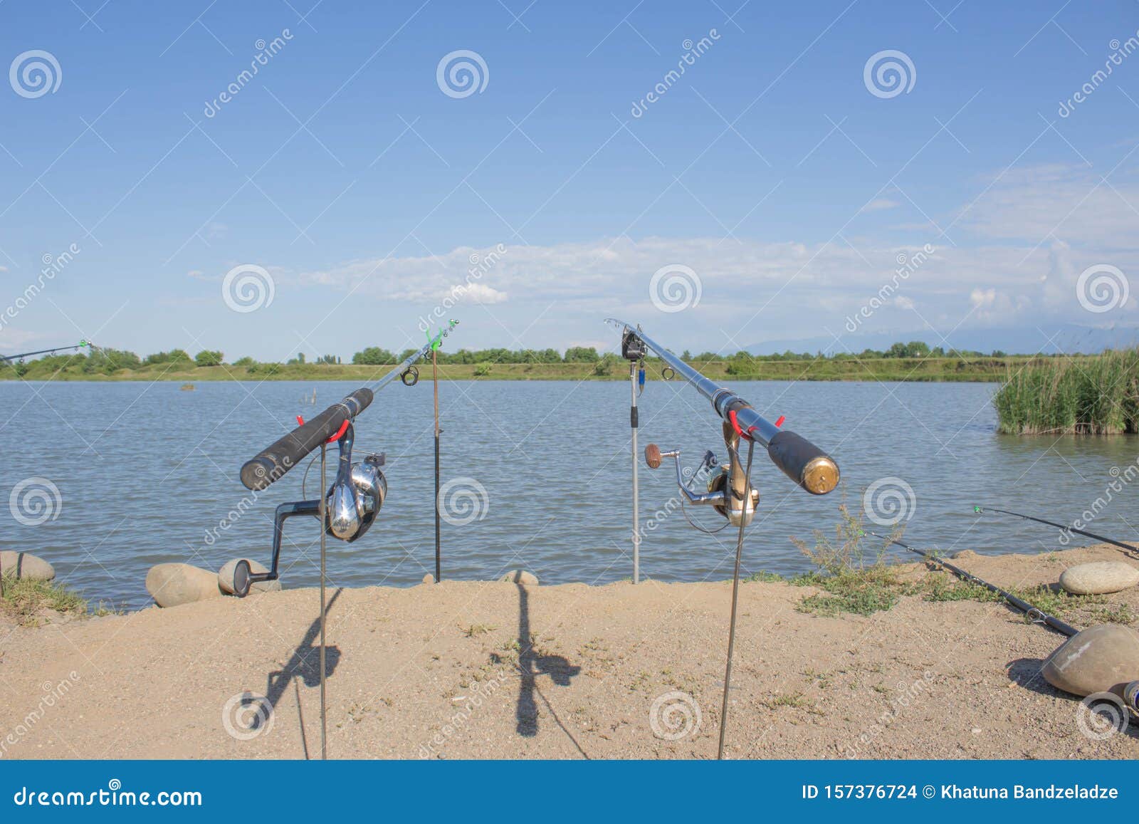 Fishing Reel on the Rod. Fishing Rods Held in Fishing Rod Holders Stock  Photo - Image of landscape, lake: 157376724