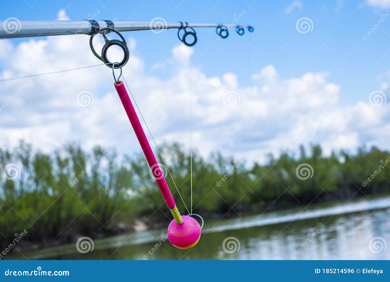 Fishing Rod Against the Blue Sky. Bright Pink Fishing Alarm Close