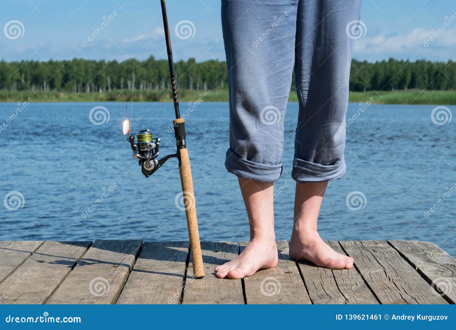 Fishing Rod and Legs of the Fisherman Stand on the Pier