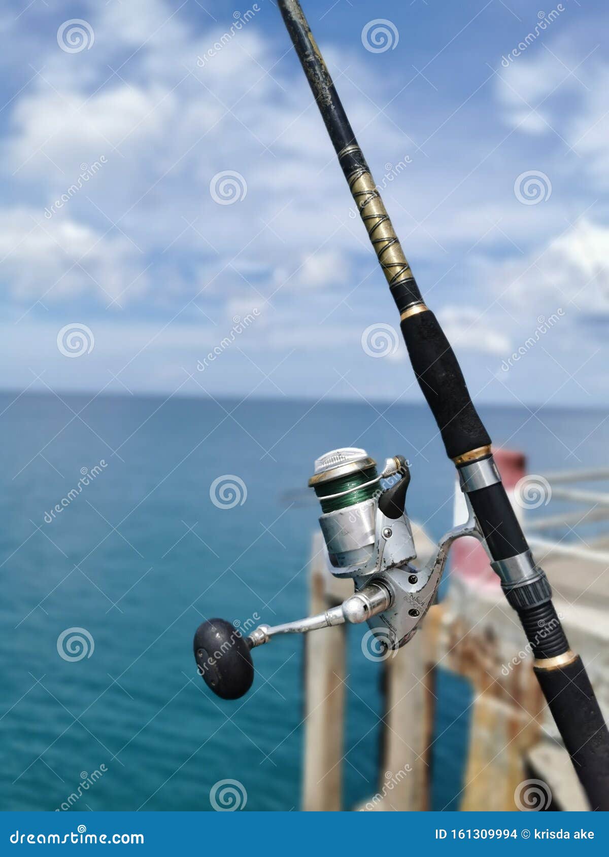 The Fishing Rod with Reel on the Beach by the Sea the South of