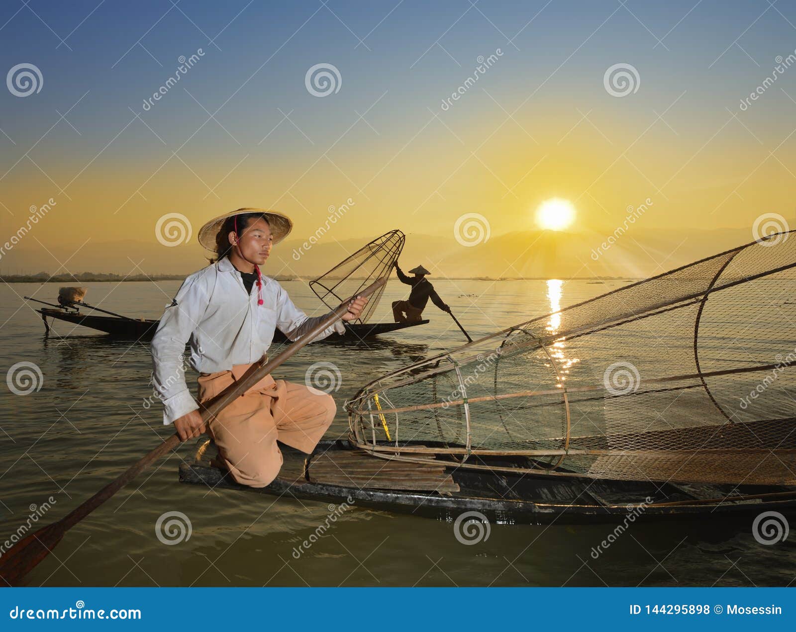 fishman and net in canoe sunrise
