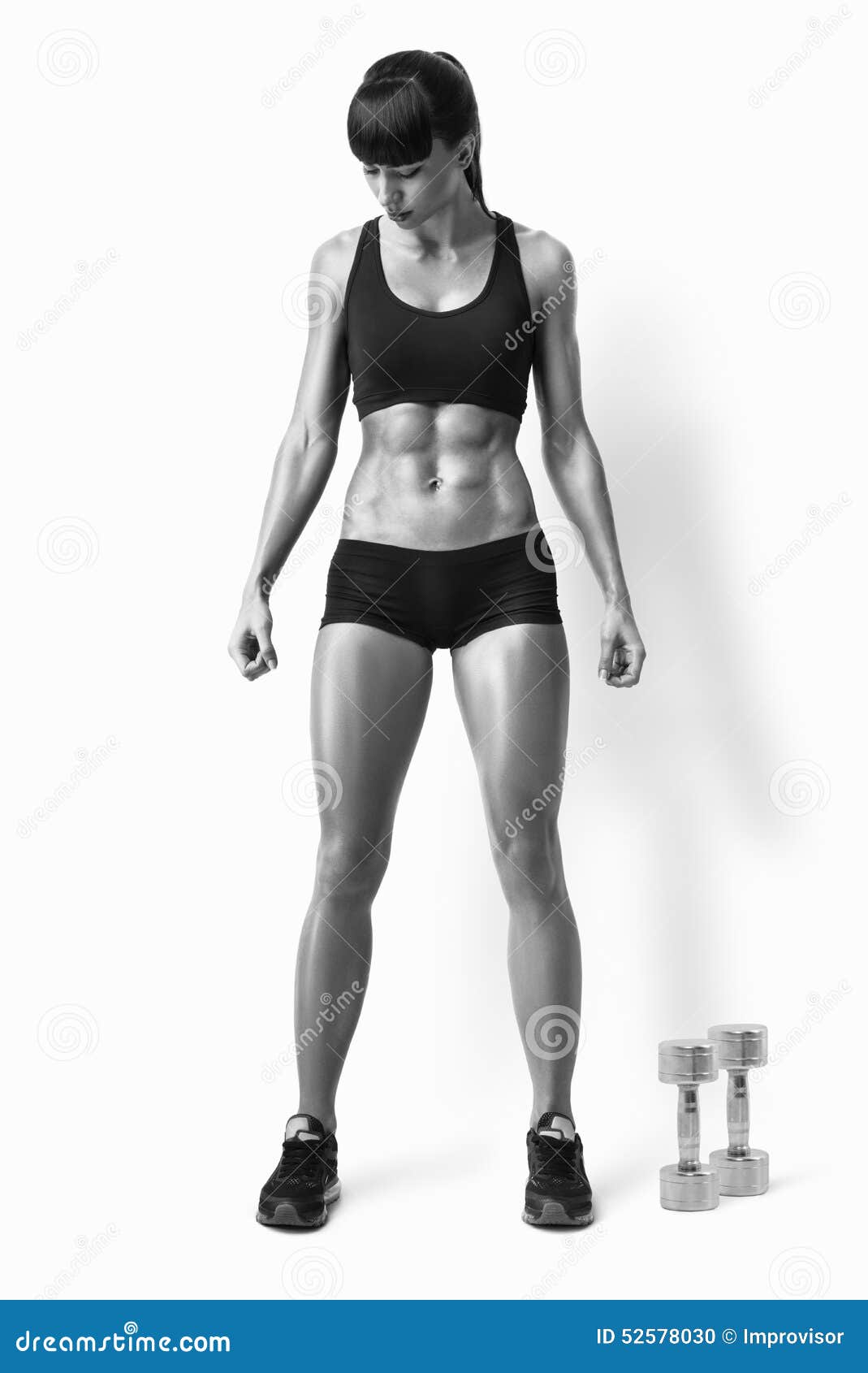 A strong athletic woman on black background wearing in white