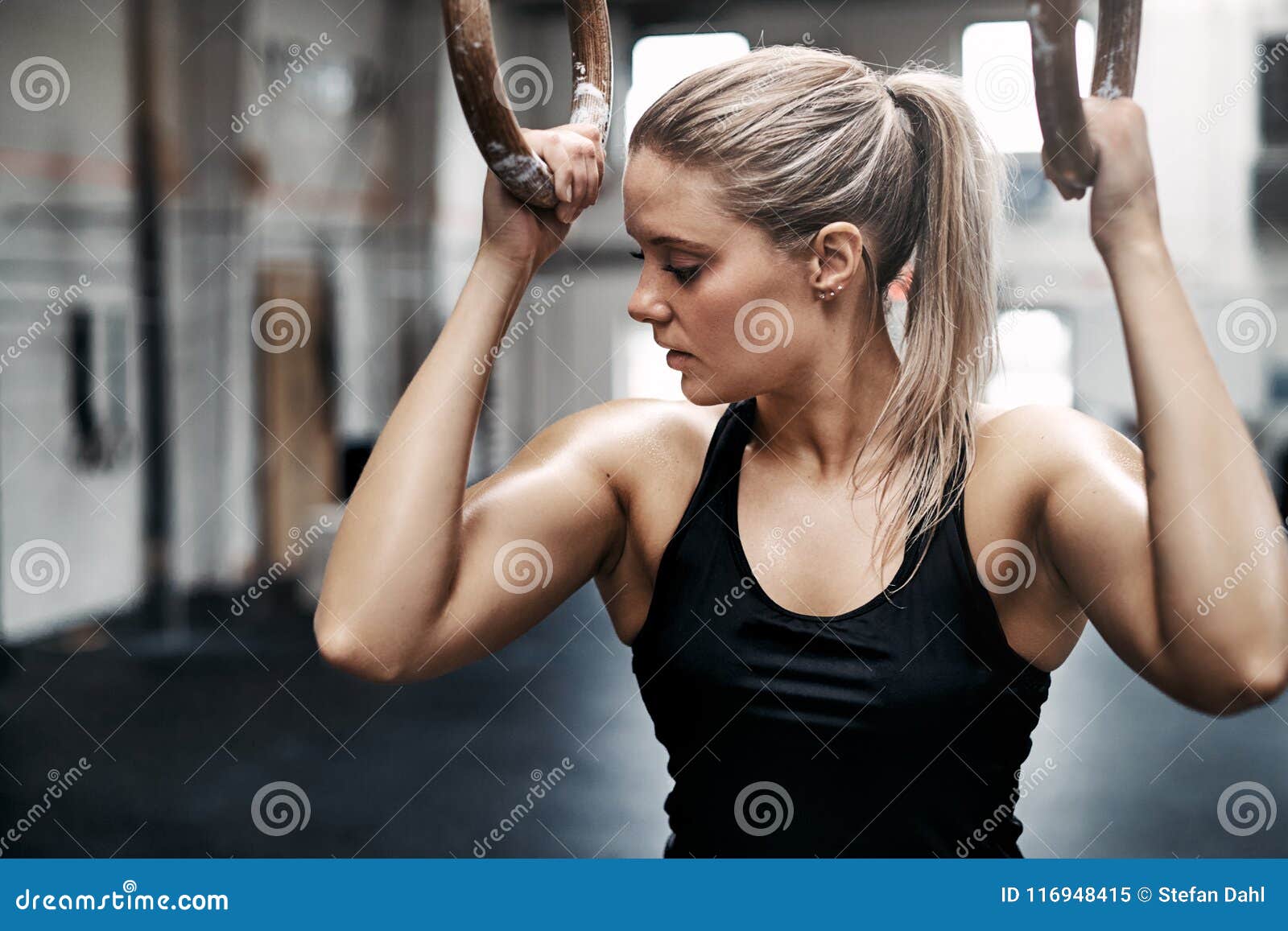 Fit Young Woman Sweating during a Gym Workout with Rings Stock