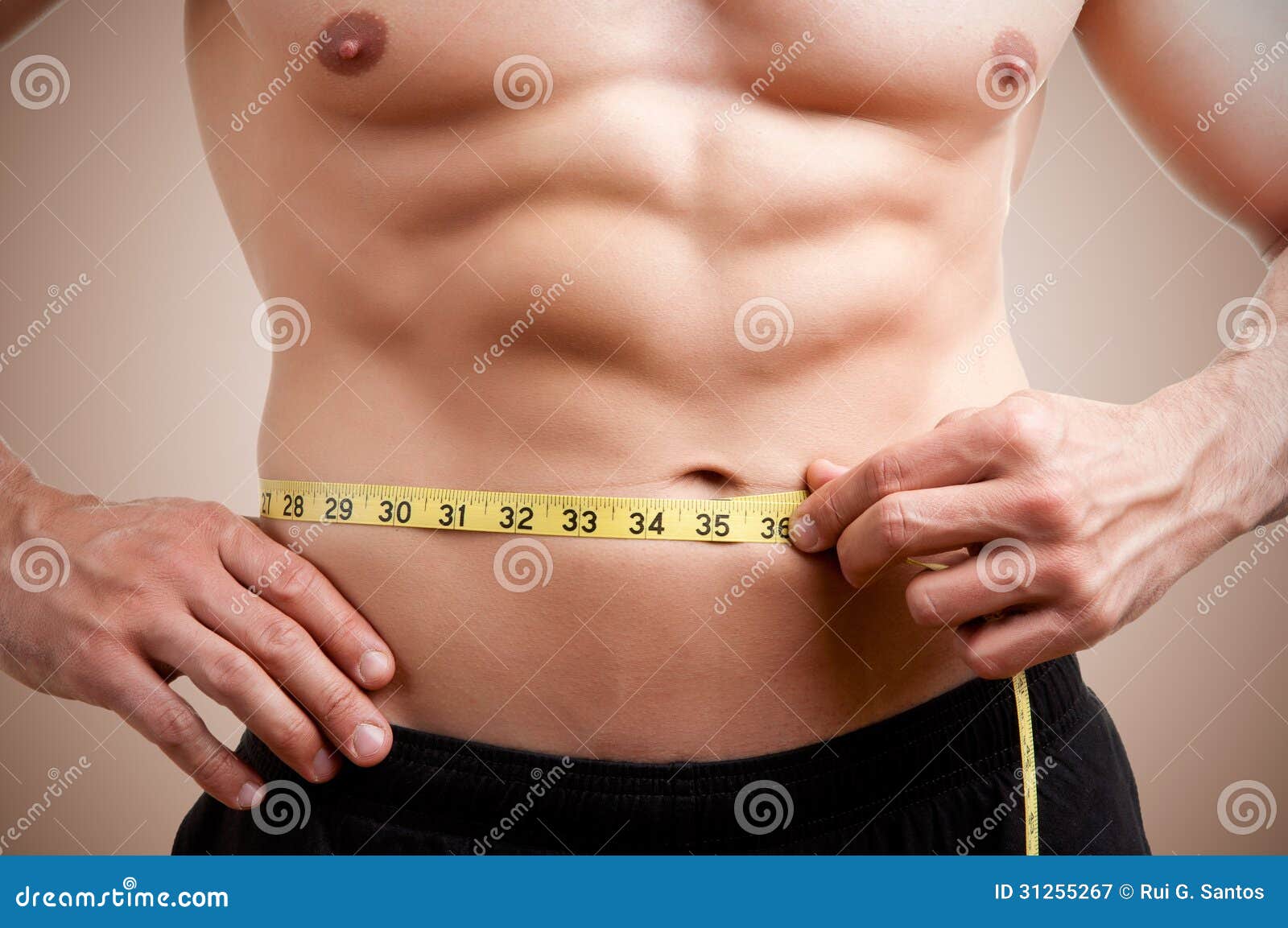 fit man measuring his waist