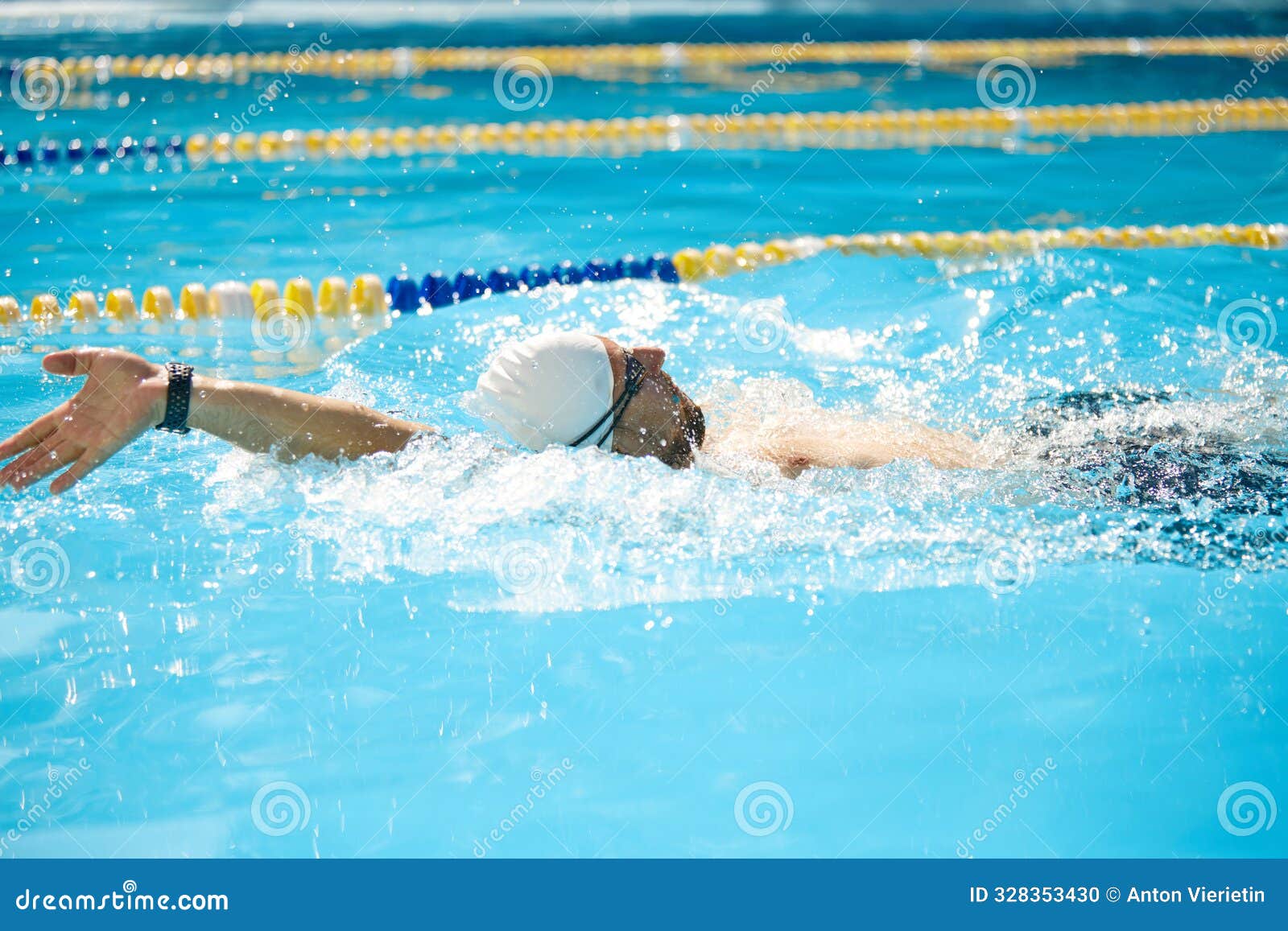 Fit Man, Swimmer, Donning White Cap, Pushes Forward in Pool, His Arm
