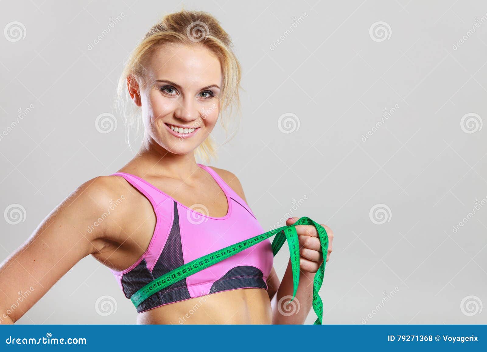 Girl Measures Her Waist Looking Down. Attractive Young Woman In Sports Bra  With Tape Measure On Background Of Sky Stock Photo, Picture and Royalty  Free Image. Image 38922572.