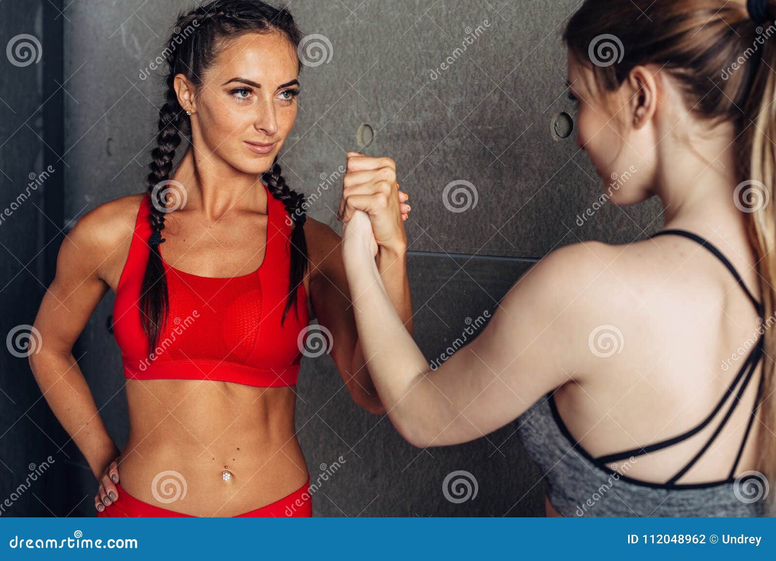 fit women holding hands with a female opponent looking in her eyes.