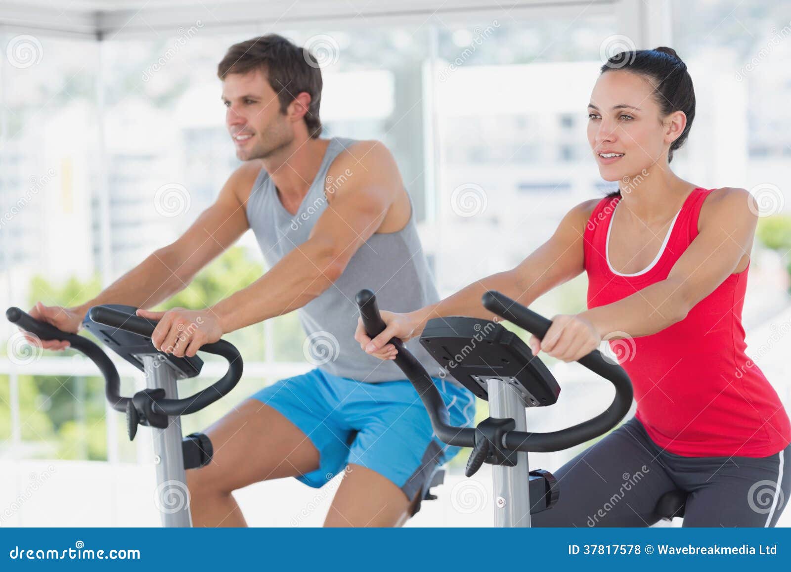 fit young couple working out at spinning class