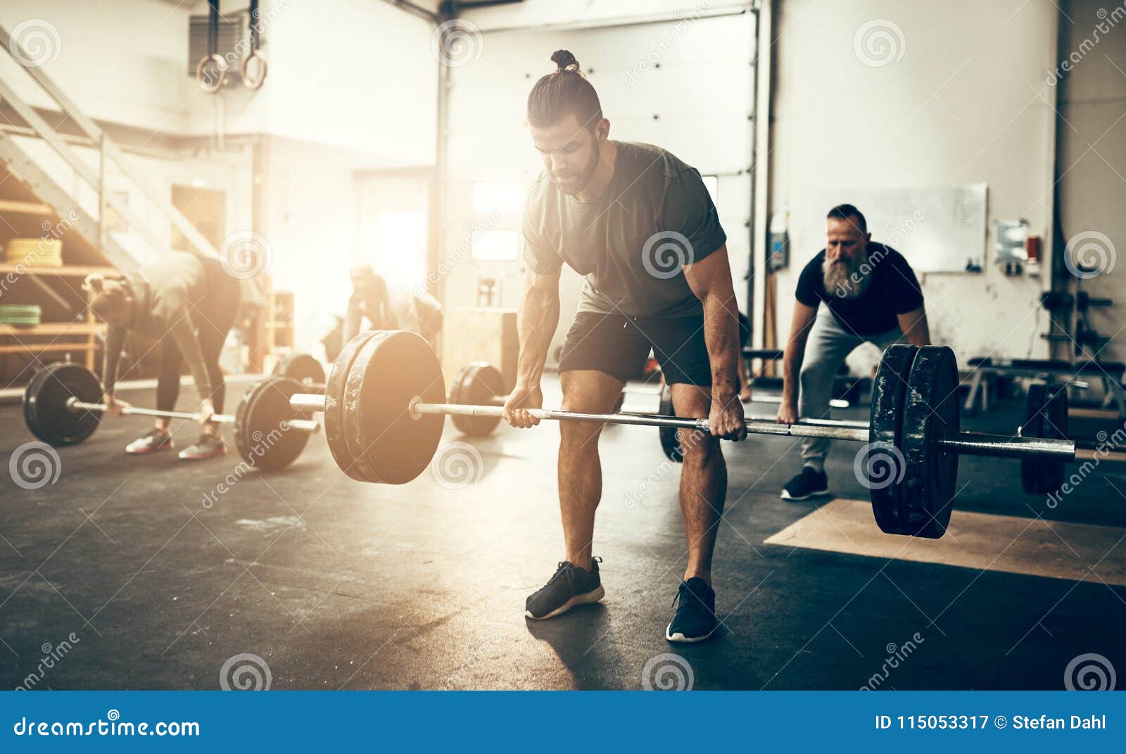 fit young man lifting weights in a gym