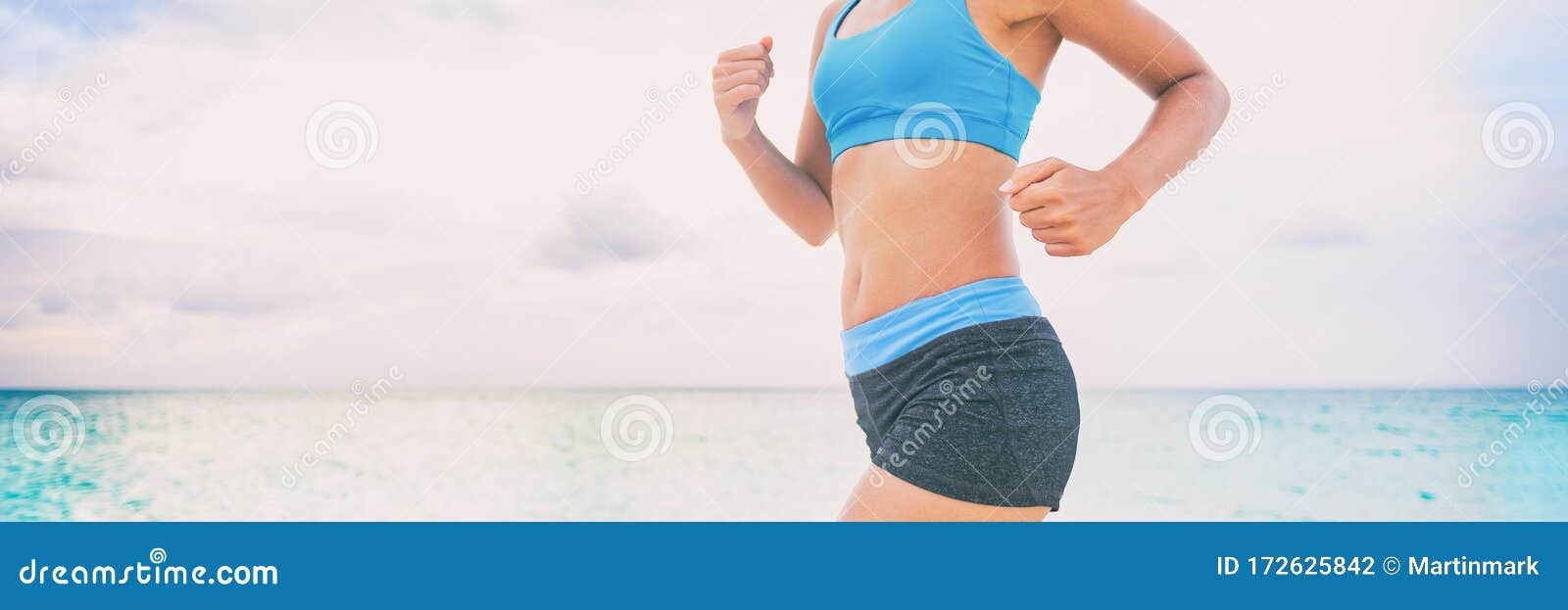 Runner woman running on beach with watch and sports bra top. Beautiful fit  female fitness model training and working out outside in summer at part of  healthy lifestyle Stock Photo